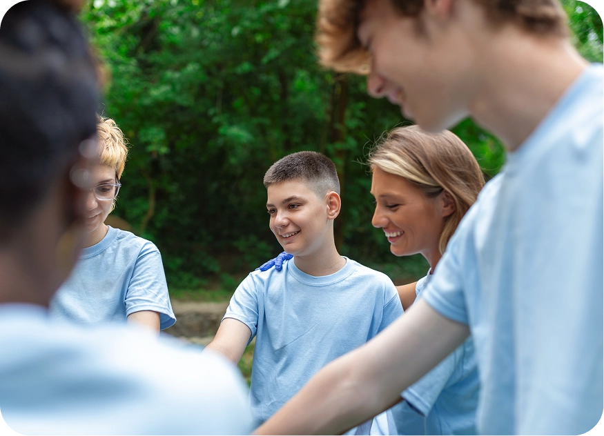 Group of young volunteers join hands together.