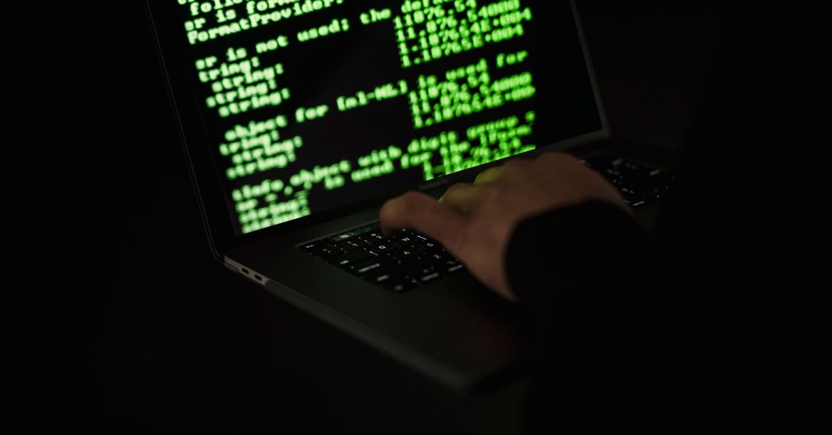 IT professional applying a security patch to a laptop in an office