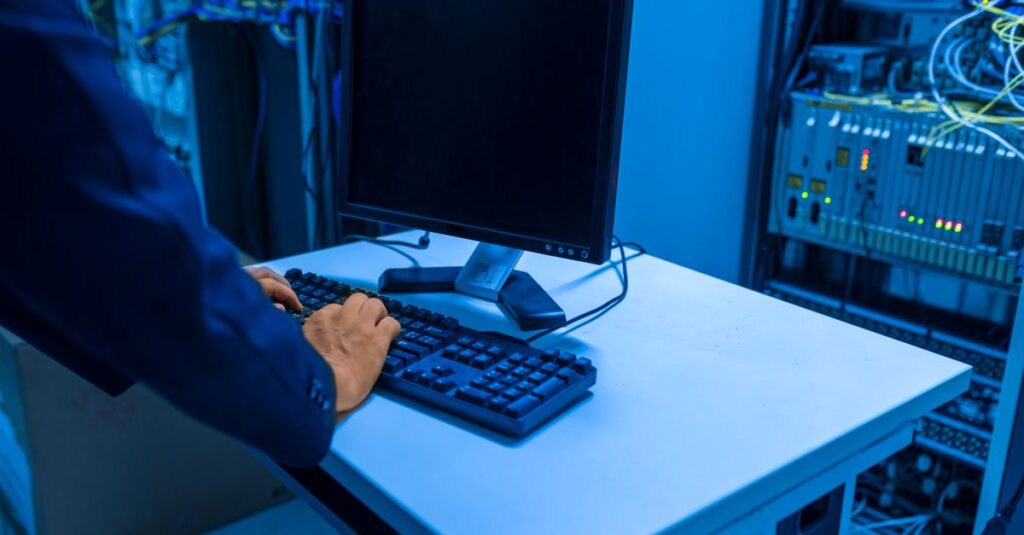 IT technician checking an on-premises server rack in an office server room
