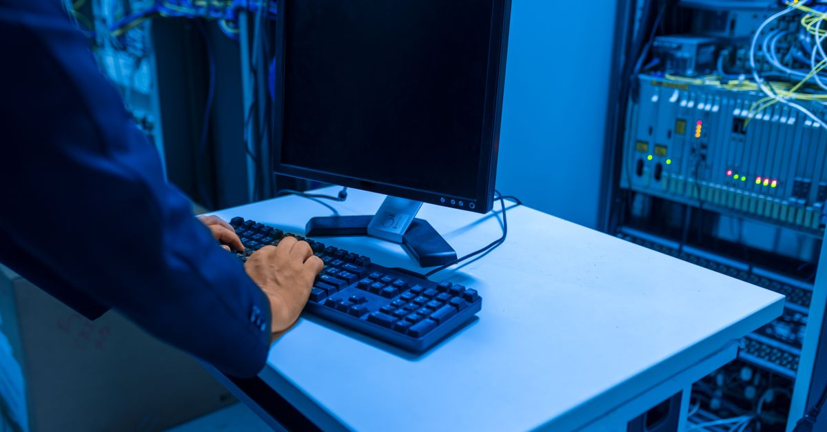 IT technician checking an on-premises server rack in an office server room