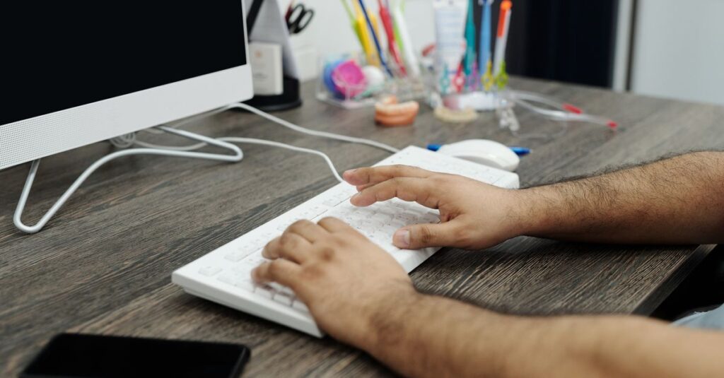 Office worker typing on a laptop running Microsoft Word at a desk, representing Office 2021 end of support